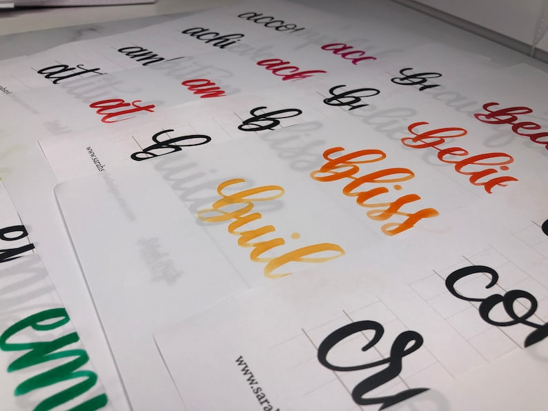 May include: A close-up of a white sheet of paper with various words written in different colors of ink. The words include "acco", "achi", "ach", "bu", "belic", "an", "an", "bliss", "co", "fulbuil", "cre", "at", "at", "f", "wwwsarabs", "em", "www.sara".