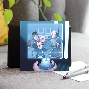 May include: A square print featuring a cartoon illustration of five men in a futuristic setting. The image is displayed on a black stand, with a hand holding a button in the foreground. Two pens and a notepad are in the foreground.