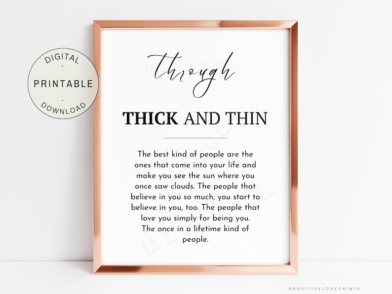 May include: A framed print with a rose gold border. The print features the words "Through Thick and Thin" in a stylish font, with a longer quote below. A circular "Digital Printable Download" graphic is in the upper left.