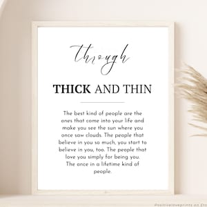 May include: A framed print with the words "through THICK AND THIN" in black script and block letters. The print includes a longer quote about the best kind of people. The background is a neutral color.
