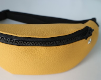 May include: A yellow fanny pack with a black zipper and black trim.