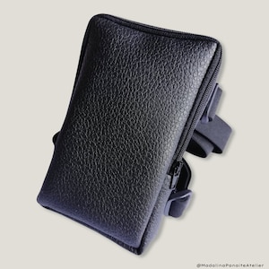 May include: Black leather phone case with a zipper closure and a black adjustable strap.