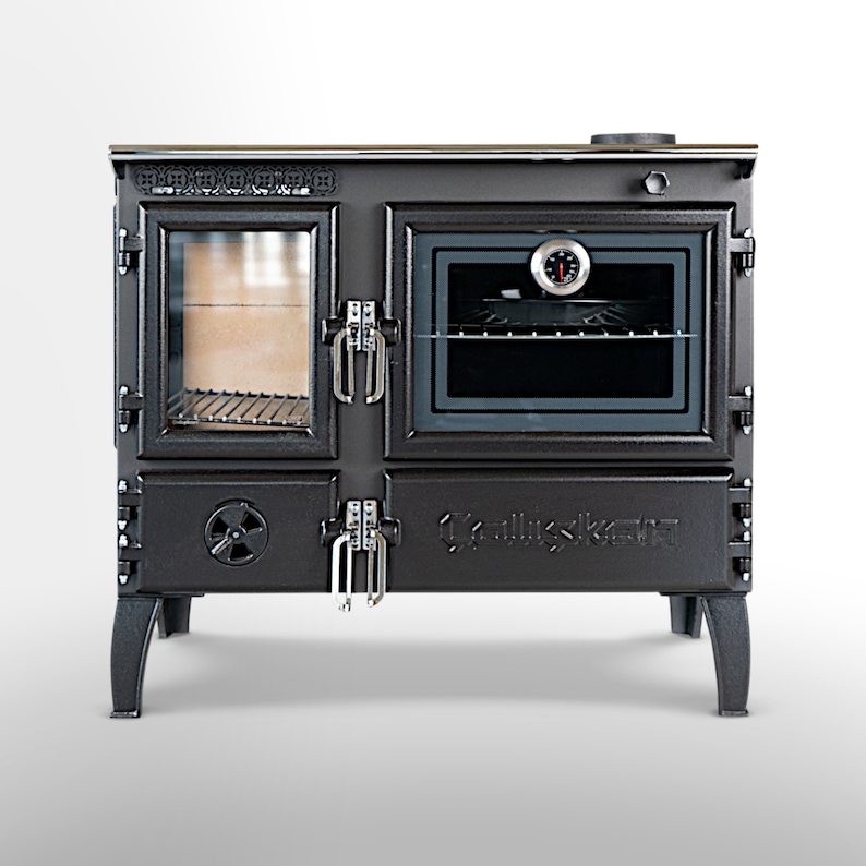 May include: A black cast iron wood-burning stove with a glass door and an oven. The stove has a thermometer on the front and the word "Kalluskett" is embossed on the front.