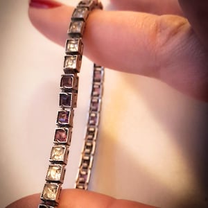 Tennisarmband 1930, Amerikaans, geïnspireerd door Cartier, in zilver bezet met gekalibreerde paarse vierkante kristallen en nepdiamanten.