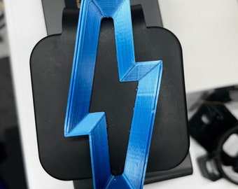 May include: A blue lightning bolt shaped 3D printed object on a black surface.