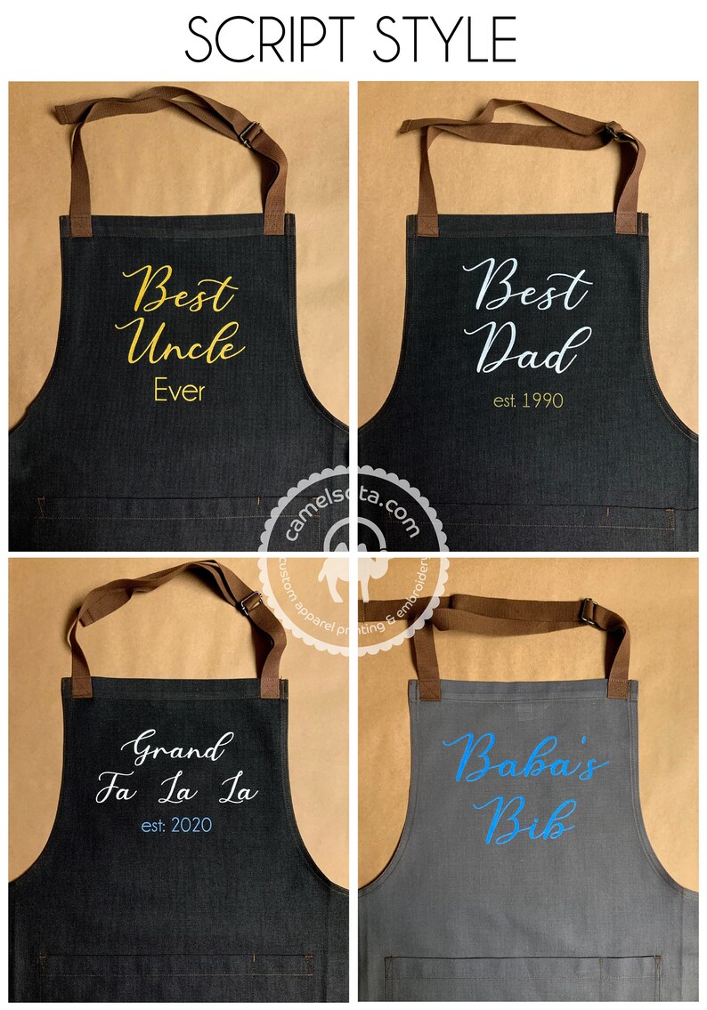 K&ouml;nnte beinhalten: Vier Sch&uuml;rzen aus Denim mit verschiedenen gestickten Texten. Die Sch&uuml;rzen sind dunkelgrau mit braunen Tr&auml;gern. Der Text auf den Sch&uuml;rzen lautet "Best Uncle Ever", "Best Dad est. 1990", "Grand Fa La La est. 2020" und "Baba's Bib".