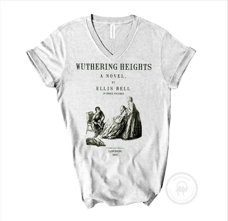 May include: A light gray V-neck t-shirt featuring a black graphic print of the Wuthering Heights book cover. The text reads Wuthering Heights, A Novel, by Ellis Bell, In Three Volumes, London: 1847, with an illustration of three figures.