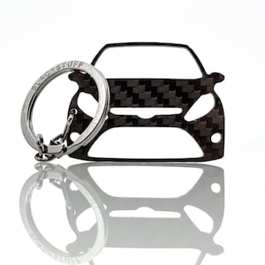 May include: A silver car keyring with a carbon fibre pattern. The keyring has a silver ring with the text "BLACK STUFF" engraved on it.