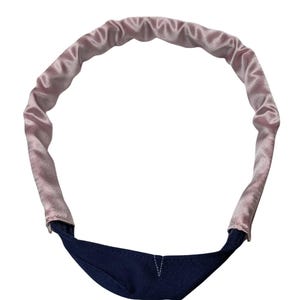 Puede incluir: Una diadema de satén rosa con forro de tela azul marino.