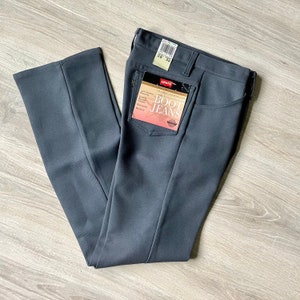 May include: A pair of dark grey Levi's Boot Cut Jeans with a size tag attached. The tag reads "Levi's Boot Cut Jeans" and has the size 28 and 32 printed on it.