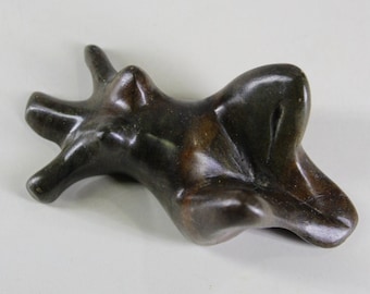 May include: A dark bronze abstract sculpture with an organic, flowing form. The sculpture has multiple protrusions and curves, suggesting a natural shape. The bronze has a polished, reflective surface, and the sculpture is set against a neutral background.