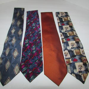 Puede incluir: Un conjunto de cuatro corbatas dispuestas una al lado de la otra. La primera es azul con un patrón de diamantes. La segunda presenta un estampado abstracto multicolor en morado, verde azulado y negro. La tercera es naranja sólida con una textura diagonal. La cuarta es una corbata con patrón azul y tostado con pequeños motivos florales y de corazones.