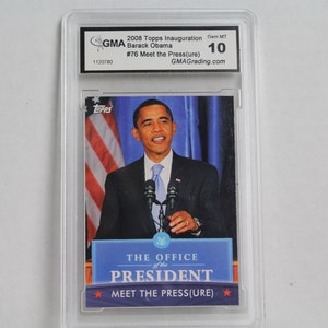 May include: A 2008 Topps Inauguration trading card featuring Barack Obama, graded Gem MT 10 by GMA. The card shows Obama speaking at a podium with the text "Meet the Press(ure)" and "The Office of the President."