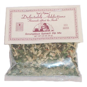 May include: A clear plastic bag containing a mix of dried vegetables and herbs, labeled "Scrumptious Spinach Dip Mix." The label, in a vintage style, reads "Delectable Addictions" and "Homemade without the Hassle." The net weight is 0.8 oz (23g).