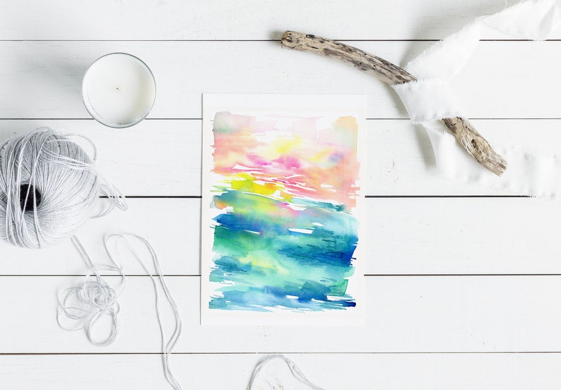 K&ouml;nnte beinhalten: Abstrakte Aquarellmalerei mit einem farbenfrohen Sonnenuntergang und einer Ozeanszene. Das Gem&auml;lde ist auf wei&szlig;em Hintergrund und in einem wei&szlig;en Passepartout gerahmt.