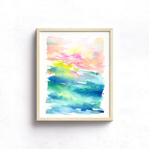 K&ouml;nnte beinhalten: Abstraktes Aquarellbild in einem hellen Holzrahmen. Das Bild zeigt eine Mischung aus rosa, gelben, gr&uuml;nen und blauen Farben in einem geschichteten, Pinselstrich-Stil.