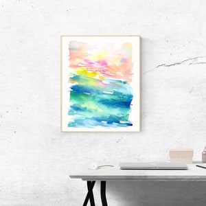 K&ouml;nnte beinhalten: Abstraktes Aquarellbild mit einem farbigen Verlauf von Rosa, Gelb, Gr&uuml;n und Blau. Das Bild ist in einem einfachen Holzrahmen gerahmt und h&auml;ngt an einer wei&szlig;en Wand.