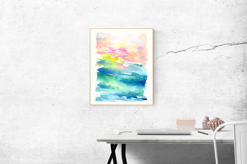 K&ouml;nnte beinhalten: Abstraktes Aquarellbild mit einem farbigen Verlauf von Rosa, Gelb, Gr&uuml;n und Blau. Das Bild ist in einem einfachen Holzrahmen gerahmt und h&auml;ngt an einer wei&szlig;en Wand.