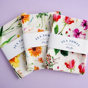 May include: Three tea towels with floral designs and the text "TEA TOWEL 18" x 24" 100% COTTON CANVAS Jane Chen" printed on the label. The towels feature watercolor illustrations of flowers and leaves.