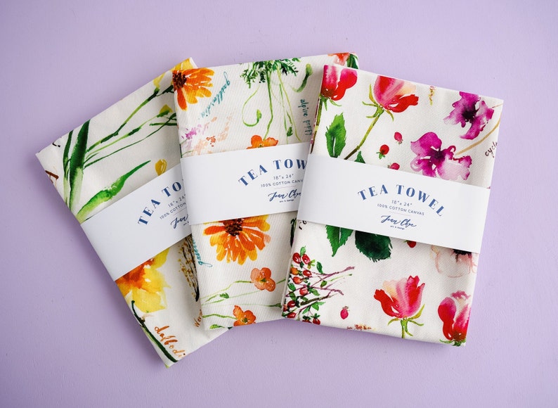 May include: Three tea towels with floral designs and the text "TEA TOWEL 18" x 24" 100% COTTON CANVAS Jane Chen" printed on the label. The towels feature watercolor illustrations of flowers and leaves.