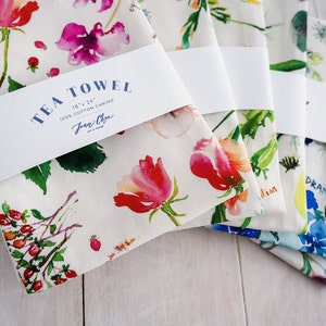 May include: Five tea towels with floral designs and names of the flowers printed on them. The towels are 18 inches by 24 inches and made of 100% cotton canvas. The brand name "Jean Oye" is printed on the label.