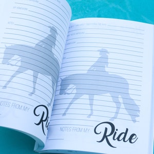 May include: Open notebook with lined pages and a silhouette of a person riding a horse. The notebook has the words "Notes from my Ride" written on the bottom of the page.
