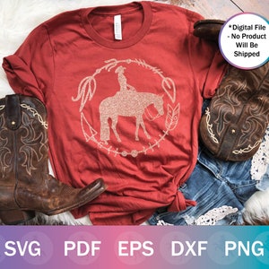 May include: Red t-shirt with a glittery design of a cowgirl riding a horse. The design is surrounded by a circle of feathers and other decorative elements. The text "Digital File - No Product Will Be Shipped" is in the top right corner of the image.