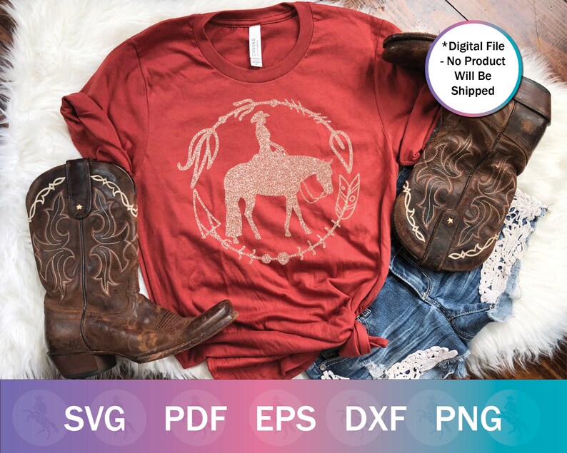 May include: Red t-shirt with a glittery design of a cowgirl riding a horse. The design is surrounded by a circle of feathers and other decorative elements. The text "Digital File - No Product Will Be Shipped" is in the top right corner of the image.