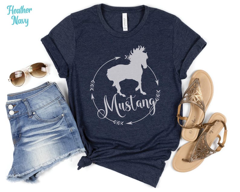 May include: A heather navy blue t-shirt with a white silhouette of a horse and the word "Mustang" in a circle.