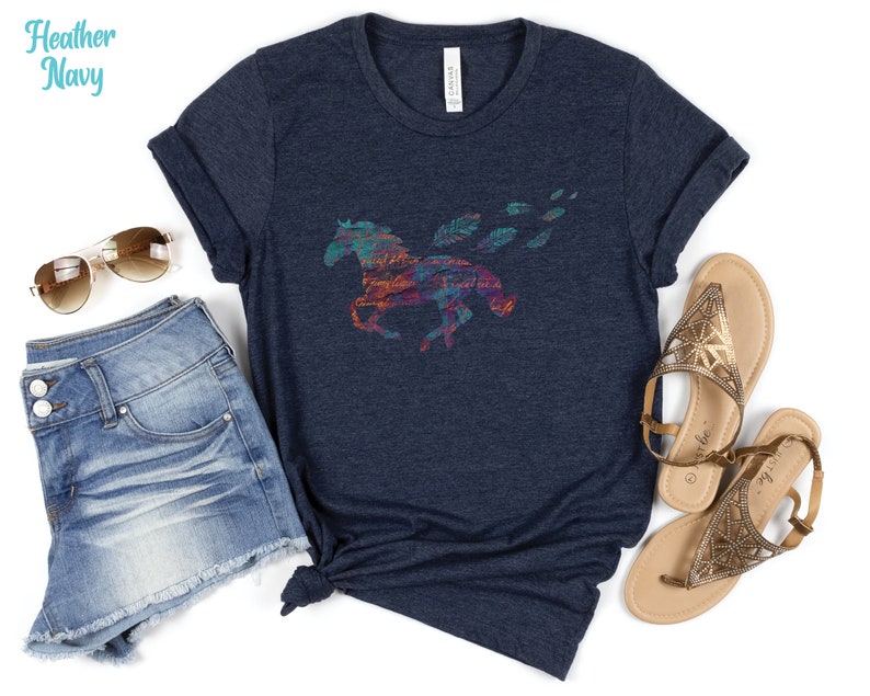 Peut inclure: Un t-shirt bleu marine chin&eacute; avec un motif de cheval abstrait color&eacute;. Le cheval court avec des plumes qui tra&icirc;nent derri&egrave;re lui.