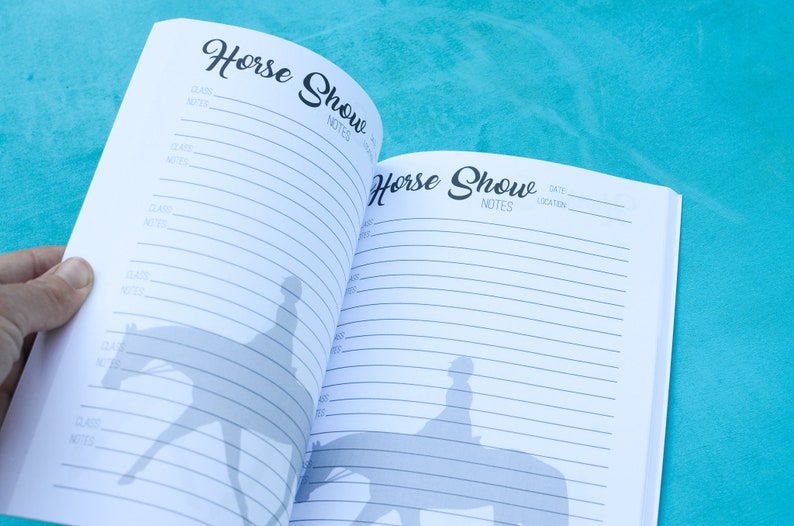 May include: An open notebook with the title "Horse Show" on the cover. The notebook has lined pages for writing notes and a silhouette of a rider on a horse on each page.
