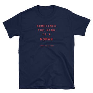 May include: Navy blue t-shirt with the text "Sometimes the king is a woman - James de la Vega" printed in red.