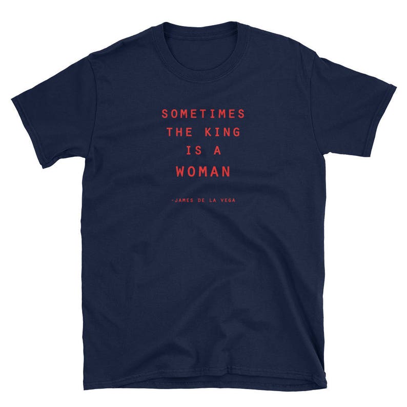 May include: Navy blue t-shirt with the text "Sometimes the king is a woman - James de la Vega" printed in red.