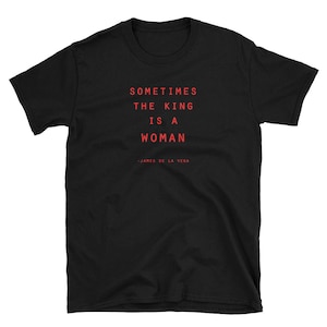 May include: Black t-shirt with the text "Sometimes the king is a woman" in red lettering. The text is attributed to "James de la Vega".