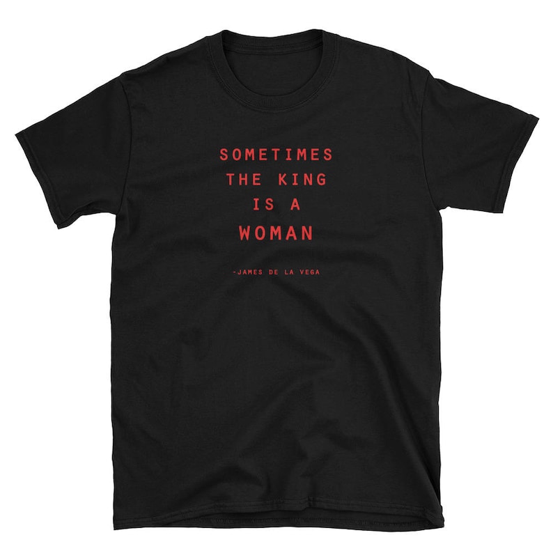May include: Black t-shirt with the text "Sometimes the king is a woman" in red lettering. The text is attributed to "James de la Vega".