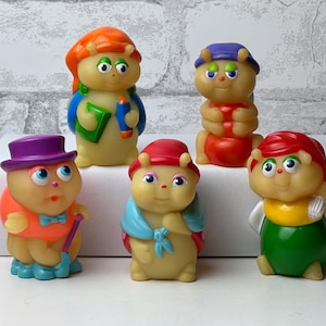 Könnte beinhalten: Eine Sammlung von fünf bunten, vintage Plastik-Käferfiguren. Jeder Käfer hat ein einzigartiges Outfit, einschließlich Hüten, Umhängen und Fliegen. Die Käfer sind in verschiedenen Posen mit unterschiedlichen Ausdrücken.