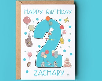 Puede incluir: Una tarjeta de cumpleaños azul y blanca con un gran número dos rodeado de globos y animales. El texto "Happy Birthday" y "Zachary" están impresos en la tarjeta.