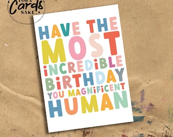 May include: A birthday greeting card with the text "Have the Most Incredible Birthday You Magnificent Human" in colorful, playful lettering. The card is white with a brown background and the words "For Cards Sake" in a circle.