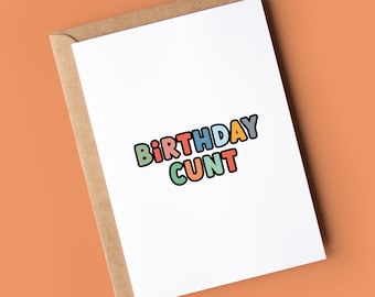 May include: A white card with a colorful birthday greeting that says "BIRTHDAY CUNT" in a playful font.