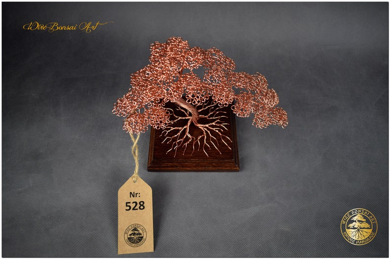 May include: A copper wire bonsai tree sculpture on a wooden base. The tree has a thick trunk and many branches. The sculpture is labeled with the number 528.