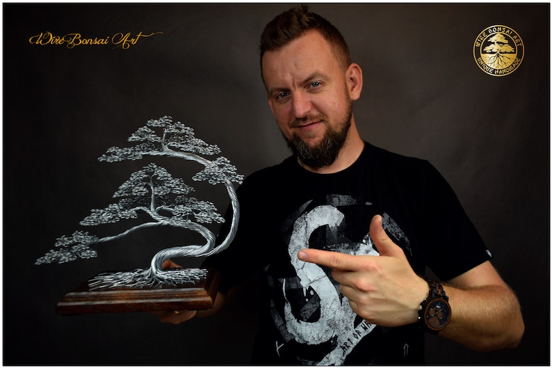 K&ouml;nnte beinhalten: Handgefertigte Draht-Bonsai-Baumskulptur. Der Baum hat ein silberfarbenes Drahtdesign mit detailliertem Laub, montiert auf einem Holzsockel. Das Kunstwerk ist mit "Wire Bonsai Art" und "Unique Handmade" gekennzeichnet.