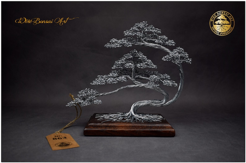 K&ouml;nnte beinhalten: Handgefertigte Bonsai-Baumskulptur aus Draht. Der silberfarbene Baum hat detailliertes Laub und einen verdrehten Stamm, montiert auf einem dunklen Holzsockel. Die Skulptur ist mit "Wire Bonsai Art" und der Nummer "863" gekennzeichnet.