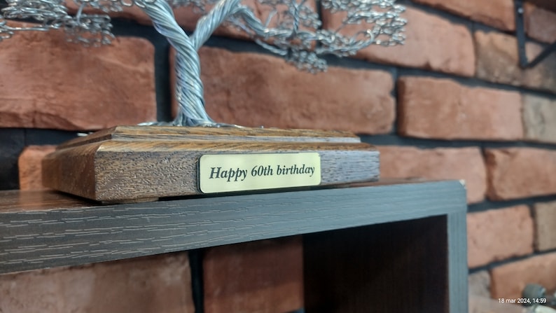 May include: A silver wire tree sculpture on a wooden base with a gold plaque that reads "Happy 60th birthday".