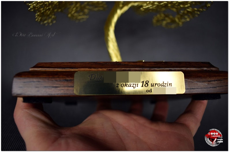 May include: A gold wire tree sculpture on a wooden base with a brass plaque that reads "Dla z okazji 18 urodzin od".
