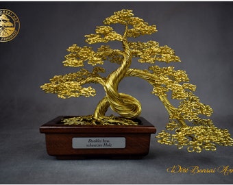 May include: A gold wire bonsai tree sculpture with a dark brown wooden base. The base has a label that reads "Dunkles Holz" which translates to "Dark Wood" in English.