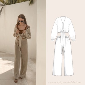 Puede incluir: Un conjunto beige de dos piezas con una blusa de nudo y pantalones de pierna ancha. La blusa tiene mangas largas y un escote en V. Los pantalones tienen cintura alta y un corte holgado.