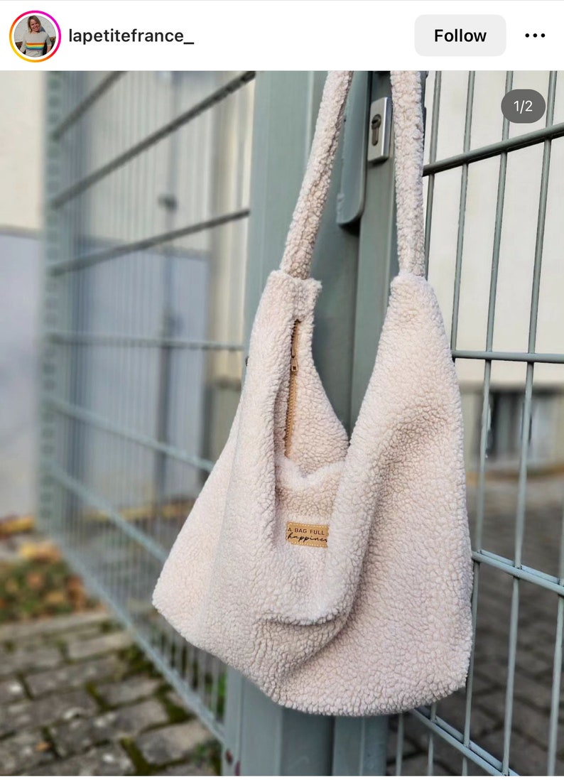 May include: A white fluffy tote bag with a zipper closure and a brown leather patch that says "A bag full of happiness".