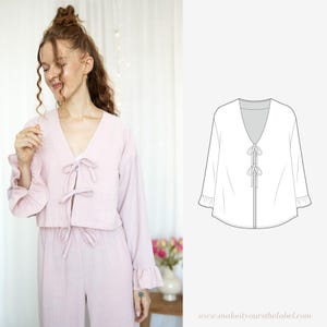 May include: A light pink, long-sleeved top with a V-neck and a tie at the front. The top has ruffles at the sleeves and a tie at the waist. The top is shown on a model.