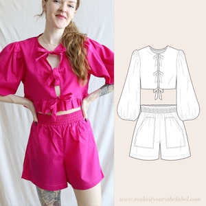 Könnte beinhalten: Ein pinkfarbenes Crop-Top mit Schleife vorne und eine passende pinkfarbene Shorts. Das Top hat einen Rüschen-Saum und die Shorts einen elastischen Bund.