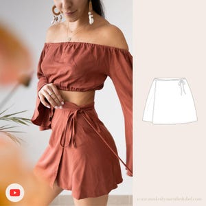 May include: Rust-colored off-the-shoulder top with long sleeves and a matching wrap skirt. The skirt has a tie closure at the waist. A sketch of a wrap skirt is on the right side of the image.